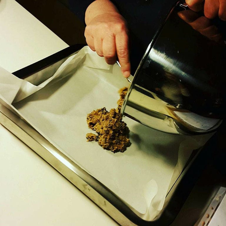 woman putting stuffing with a spoon on the dough at 'The Trinity Farm'